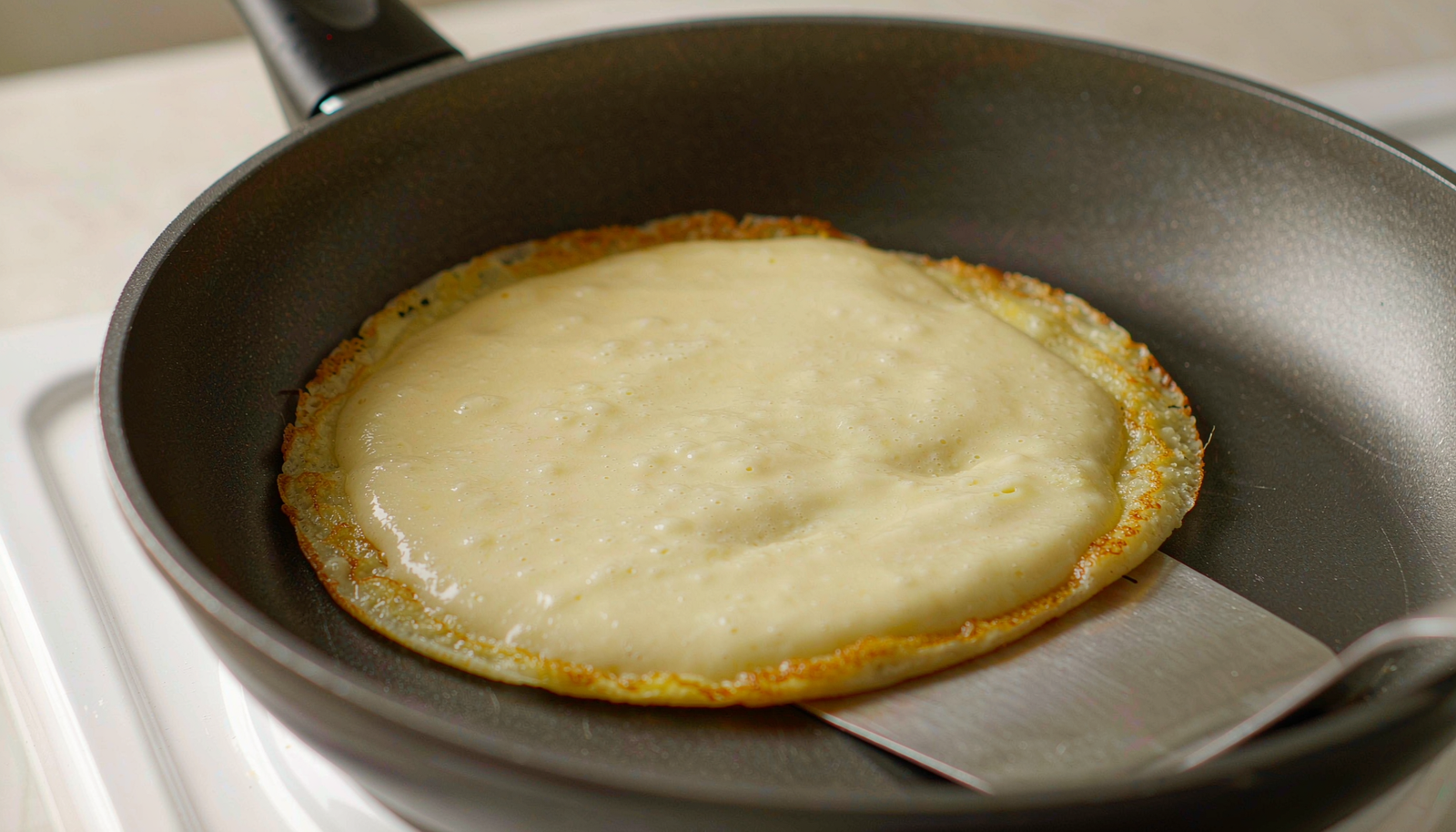 Massa de panqueca simples sendo preparada na frigideira